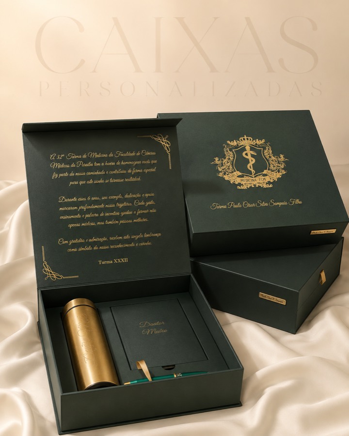 Caixa verde personalizada aberta com kit de formatura: garrafa térmica dourada, caderno e caneta, com mensagem em dourado na tampa