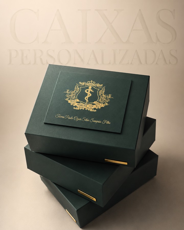 Três caixas verdes personalizadas empilhadas, com brasão dourado e puxador metálico